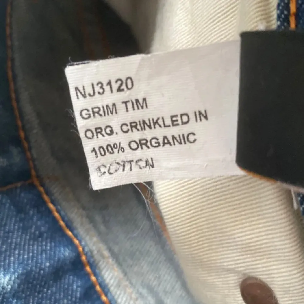 Säljer ett par blå Nudie Jeans 'Grim Tim' i 100%  bomull. Är i riktigt bra skick och har snygga slitningar.. Jeans & Byxor.