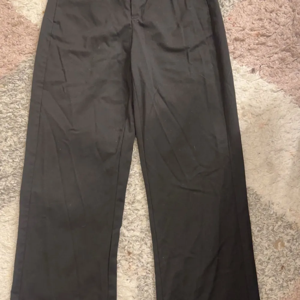 Snygga svarta kostymbyxor med elastisk midja och raka ben. Perfekta för en stilren look.. Farkut & Housut.