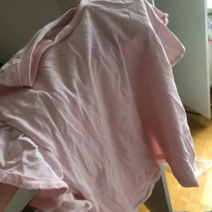 Ljusrosa topp med volangärmar - Säljer en söt ljusrosa topp med volangärmar. Toppen är ärmlös och har en rund halsringning. Perfekt för sommaren eller en festlig tillställning. Den är i bra skick och väldigt bekväm att ha på sig. passar xxs- m