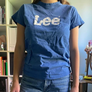 T-shirt Lee - Blå t-shirt från Lee. Köpt secondhand. Lite sliten runt kragen men annars hel och snygg!
