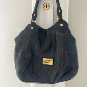 Marc by Marc Jacobs väska  - Äkta svart Marc by Marc Jacobs väska. Den är i väldigt bra skick, utan något synligt slitage. Väldigt trendig just nu och perfekt som skolväska eller handväska. Skriv om ni har fler frågor. 