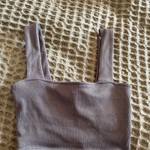 Croppat Linne - Ett mörkgrått ribbad linne från hm divided. Använd kanske 2 gånger. Nypris 150kr.