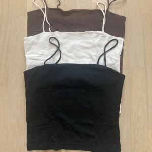 Svart axelbandslös topp från Gina Tricot - Säljer tre toppar från Gina trikot. Alla för 35 eller en för 15. Alla är i storlek S. OBS den bruna är såld