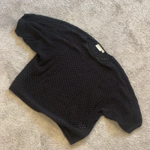 Svart stickad tröja  - Säljer denna svarta stickade tröjan från Kappahl. Skriv till mig om ni vill se hur den sitter på. Snyggt med ett linne under. Använd Max 5 ggr. Inga defekter!  Köparen står för frakt och använd gärna köp nu! 