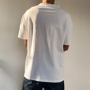 Vit t-shirt - Säljer en klassisk vit t-shirt i bomull. Den har en oversized passform och korta ärmar, perfekt för vardagsbruk. Enkel och stilren design som funkar till allt!