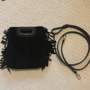 Maje väska  - Säljer min Maje väska! Svart mocka i den lilla storleken 💝 nyligen inköpt så den har super fint skick. Inga defekter, repor eller skador. Du får med det långa läder bandet, som är justerbart. Nypris : 2700kr 💞skriv om du har funderingar !! 😚