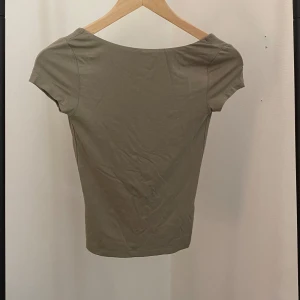 Grön topp med öppen rygg - Topp från Gina tricot med öppen rygg. Använd ett fåtal gånger och mycket tjockt och bekvämt material! En jättefin grön färg!!!♻️💕