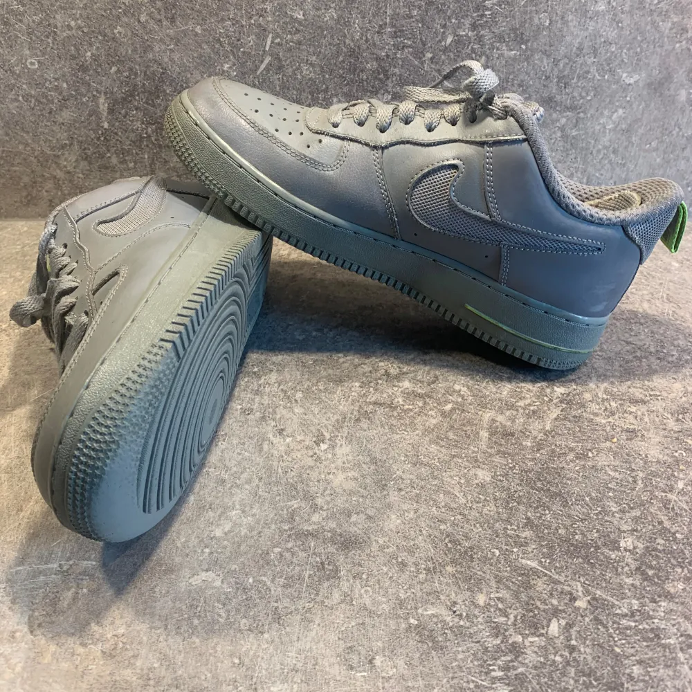 Säljer ett par grå Nike Air Force sneakers i bra skick. Sparsamt använda i lite över ett år, haft hälinlägg för att skydda tyget där bak. lite sliten innersula samt enstaka smutsfläckar på utsidan av skorna, annars bra skick.. Skor.