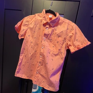 Orange kortärmad skjorta med palmmönster - säljer en skjorta från Lindex som aldrig är använd och har bara legat i garderoben. vid funderingar och frågor så är det bara att höra av sig svarar på 🌴