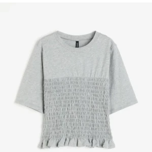 grå smockad topp - super snygg och populär grå smockad topp från h&m som är slutsåld, super bra skick men kommer tyvärr inte till användning.