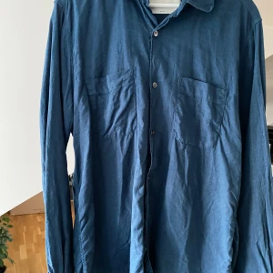 Blå linneskjorta - Säljer denna blåa linneskjortan från A days march. Den är endast använd en gång och därefter inte kommit till användning. Den är i väldigt bra skick. Den sitter som en medium.