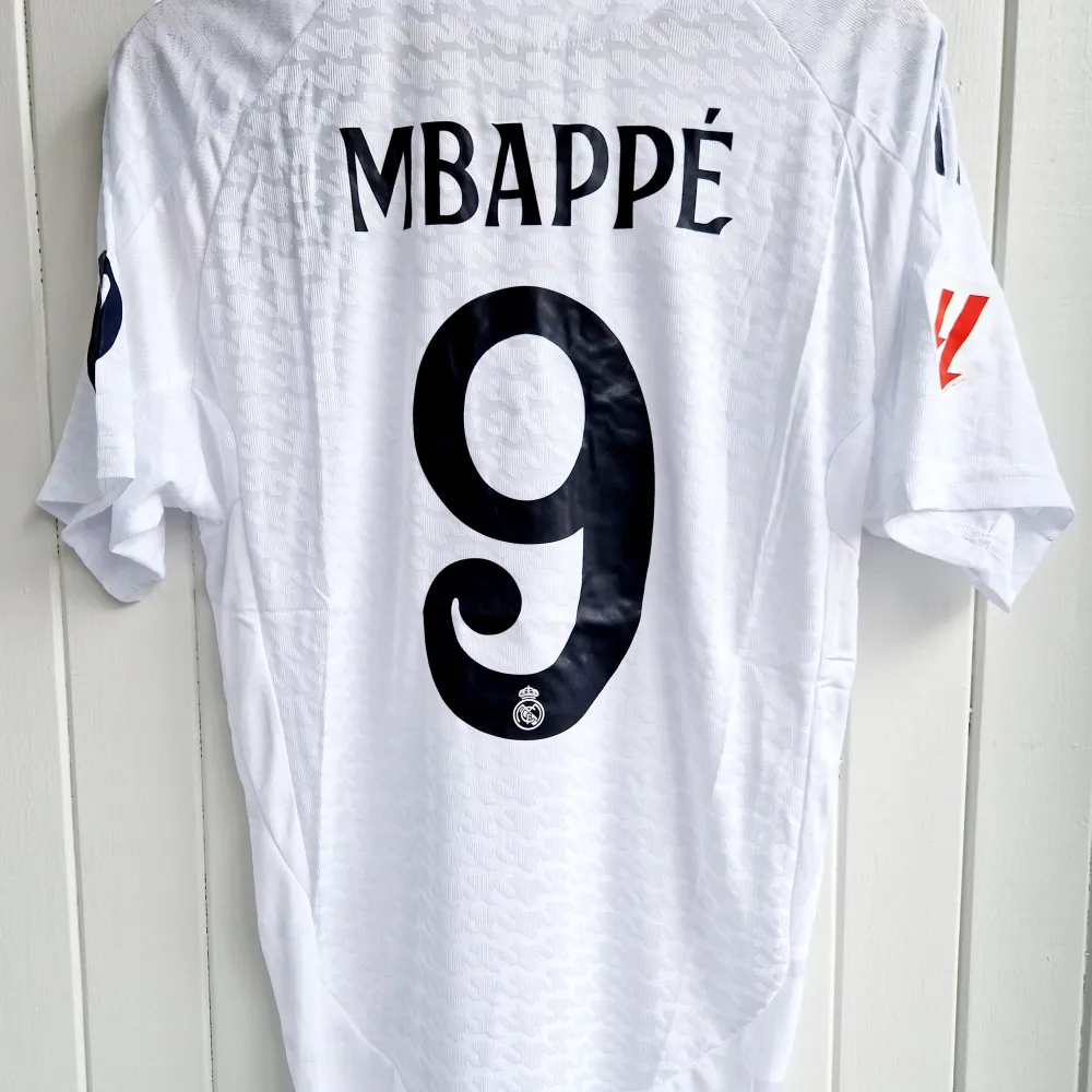 Säljer Real Madrids matchtröja för kommande säsong 2024/25 med Mbappe på ryggen. Tröjan är en reprint i nyskick med emblem och patchar av högsta kvalité. Tröjan är en player version. Tajt i storleken. . Sportswear.