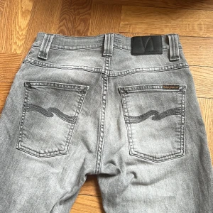 Gråa Nudie Jeans  - Gråa Nuide Jeans i Slim fit modellen ”Grim Tim”, knappt tecken av användning. Nypris 1600, mitt pris 699! Hör av dig vid frågor eller funderingar