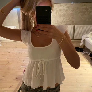 Vit ribbad topp från Nelly - Säljer en superfin vit ribbad topp från Nelly. Toppen är i nyskick aldrig använd. Den är slutsåld. Nypris ligger på 280kr! 🥰