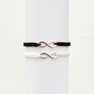 Svart och vitt armband ( extra gåva på köpet) - Två stilrena armband i svart och vitt med en silverfärgad oändlighetssymbol i mitten. Perfekta för att bära tillsammans eller ge bort som en vänskapsgåva. Armbanden har en enkel och elegant design som passar till alla tillfällen.