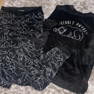 Svart mysig pyjamas med björnmönster - Säljer en supermysig svart pyjamas i storlek XS från märket Cubus. Tröjan har ett gulligt björnmönster och texten 'Bearly Awake' på framsidan. Perfekt för en chill dag hemma eller som en rolig present! 🐻