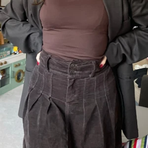 Mörkbrun söt vintage kjol - Kjol i Manchester tyg. Köpt second hand och använd ca 3 gånger av mig.   Står storlek 34 men passar mig perfekt som har storlek 38. Går till lite över knäna.