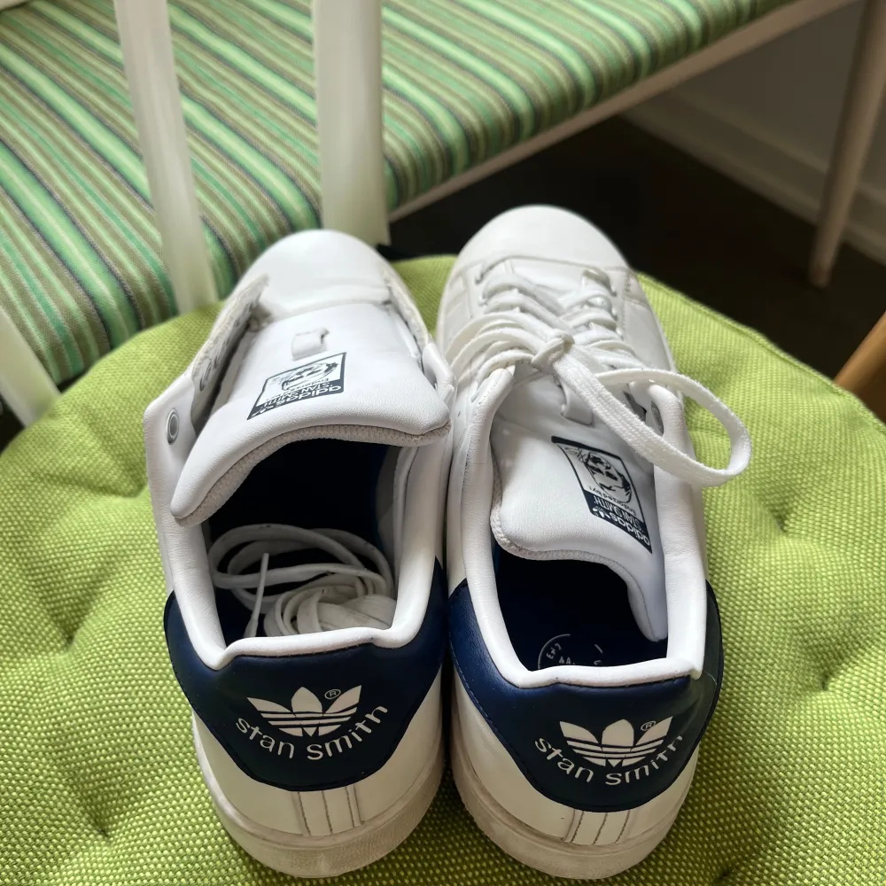 Stan Smith ungdomsskor i vit med marinblå detaljer i storlek 38. Fint skick, köpta i februari 2024. Säljer pga lite för små för mig. Nytvättade.   Jag kan mötas upp i Stockholm :). Skor.