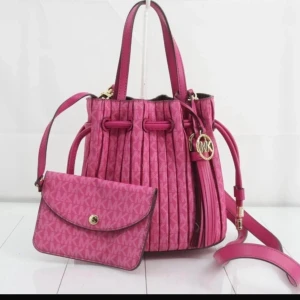 Rosa axelväska med mönster - Säljer en superfin rosa axelväska från Michael Kors. Väskan har ett snyggt quiltat mönster och är gjord i syntetmaterial. Den har en dragkedja och en justerbar axelrem. Perfekt för både vardag och fest!