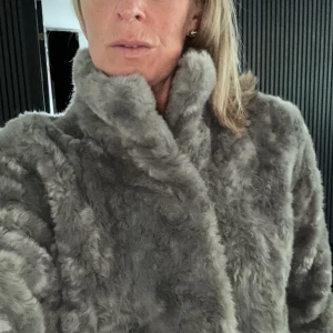 Grå Fuskpäls - Grå fuskpäls från Tiger of Sweden i fint skick. Varm och go och mkt stilig på.