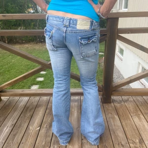 Low Waisted Bootcut Jeans - Low Waisted Bootcut Jeans i nyskick köpta second hand. Detaljer vid knäna och gula stygn runt midjan. Midjemått rakt över 40 cm, ytterbenslängd 101 cm, innerbenslängd 85 cm. Skriv vid funderingar✨