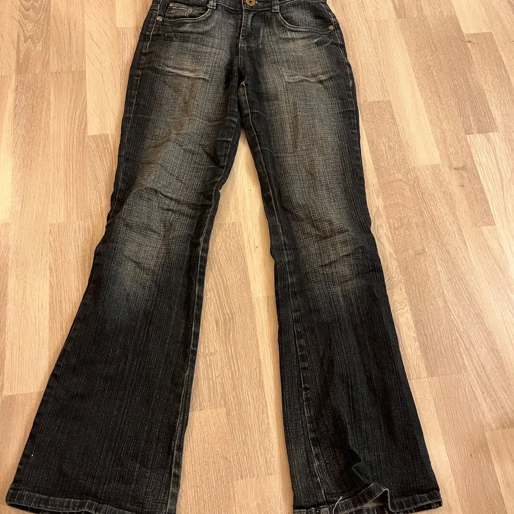 Säljer ett par snygga lågmidjade mörkblå jeans från Miss O&y. De har coola broderade kronor på bakfickorna och en unik design på baksidan. Jeansen är bootcut och stretchiga.. Jeans & Byxor.