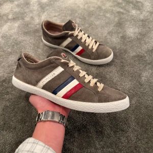 Moncler Skor - Säljer nu dessa riktigt snygga Moncler skor i storlek 42! Snygga i brun mocca med Moncler detaljer, perfekt till vår/sommarn! Skick 7/10, endast skor ingår. Hör av dig vid funderingar, snabb affär = bättre pris!🌟🍾💯