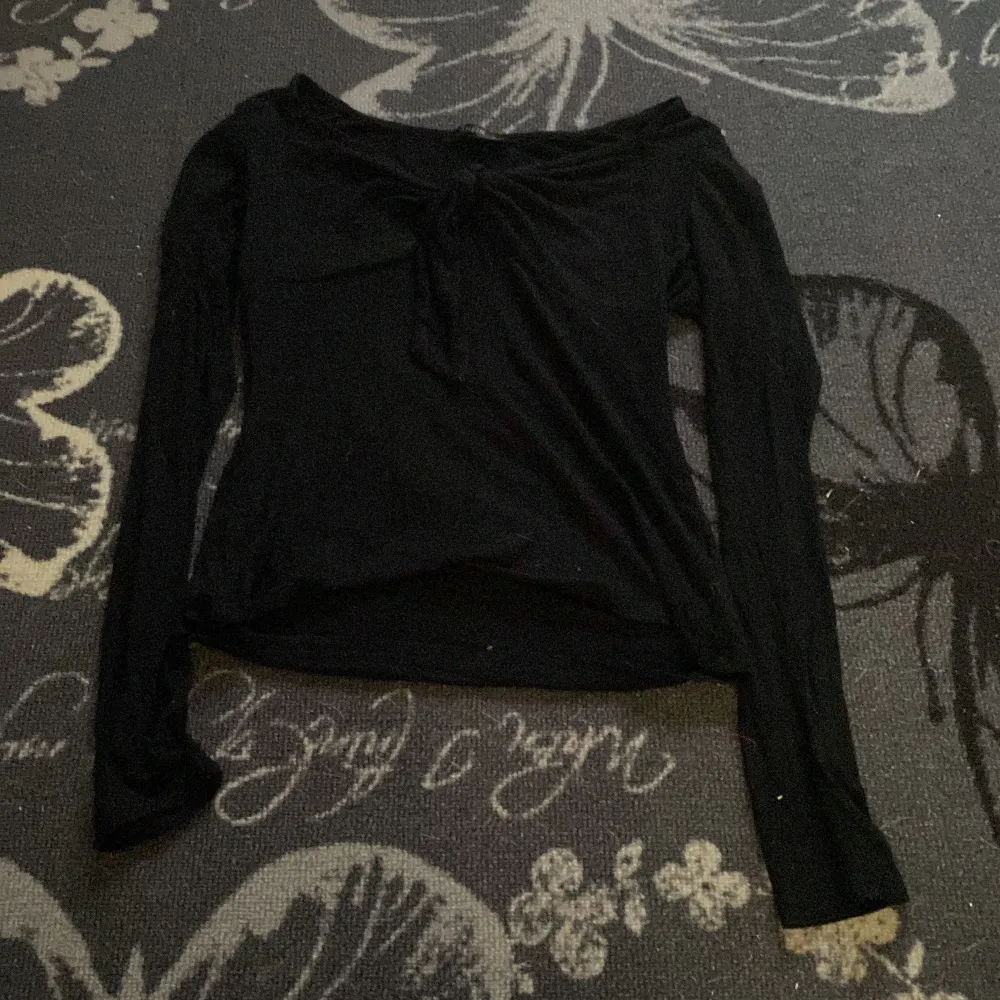 Säljer en svart långärmad topp från Shein med knytning framtill. Perfekt för en stilren look. Toppen är i ett mjukt material och har en elegant design. Aldrig använt den💕. Yläosat.