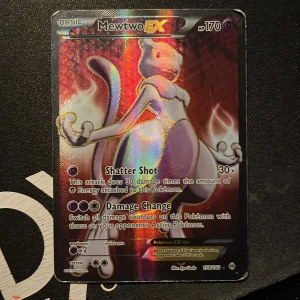 Mewtwo EX Pokémonkort - Säljer ett Mewtwo EX Pokémonkort med 170 HP. Kortet har en holografisk yta och innehåller attacker som Shatter Shot och Damage Change. Perfekt för samlare eller Pokémon TCG-spelare!