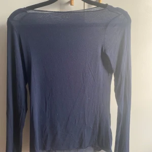 Mörkblå långärmad topp från Intimissimi - Säljer en mörkblå långärmad topp från Intimissimi. Toppen är i ett mjukt och bekvämt material som passar bra till olika tillfällen. Helt ny och oanvänd med prislapp kvar.