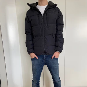 Svart jacka - Snygg svart pufferjacka med dragkedja och hög krage. Perfekt för kyliga dagar med sin vadderade design. Jackan har långa ärmar och en stilren look som passar till det mesta. Skick 8.5/10. Modellen är 173. 
