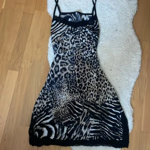 Leopardmönstrad klänning/nattlinne med spetsdetaljer - Snygg leopardmönstrad sommar klänning/nattlinne I satin material med smala axelband och spetsdetaljer vid bysten. Perfekt för en djärv look med sitt unika mönster som kombinerar leopard och zebra. 