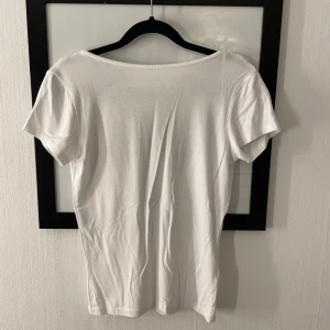 T-shirt  - En vit T-shirt med urringad rygg andvänd en gång. Priset kan diskuteras 