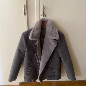 Grå jacka med foder - Säljer en snygg grå jacka med mjukt foder och dragkedja. Köpt från HM.Storlek 36 men modellen är oversized. Dragkedjorna funkar bra. Sparsamt använd. Har små skavanker men inget som syns vid användning eller som stör funktionen. Tyget är lite nopprigt. Längs kanterna är den lite ”tufsig” men tror det är så den ska se ut då den var så när jag köpte den (Se bilder) mer bilder kan skickas om så önskas.  Tvättas innan frakt. Pris kan diskuteras😊 köparen står för frakt!