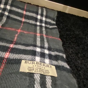 Rutig halsduk från Burberry - Säljer en grå Burberry halsduk i 100% Lambswool. Den är väldigt snygg och den är sparsamt använd. Nypris ligger på 5230kr och mitt pris är 799kr. Hör av er vid frågor eller funderingar!