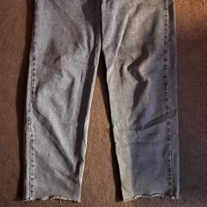 Säljer ett par grå jeans från Collusion. De har en baggy passform. Perfekta för en avslappnad stil med råa kanter vid bensluten. Säljer för att de är för små, riktigt bra skick, 32/32.