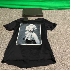 Limitato - Snygg svart t-shirt från Limitato med ett ikoniskt tryck på baksidan. T-shirten har en klassisk rund hals och korta ärmar. Perfekt för dig som vill ha en stilren look med en twist. Boxen och tag följer med! 