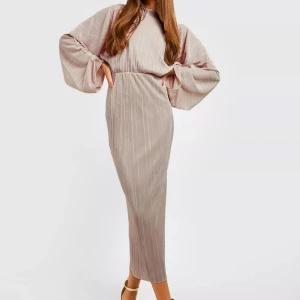 Beige långklänning med vida ärmar - Elegant beige långklänning med vida ärmar och ett subtilt randigt mönster. Klänningen har en hög hals och en smickrande passform som framhäver midjan. Perfekt för en stilfull look.