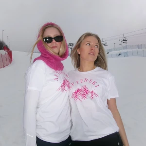 Vit t-shirt med rosa tryck - Snygg vit t-shirt med rosa bergsmotiv och texten 'AFTERSKI' på bröstet. Perfekt för en avslappnad stil i skidbacken eller på afterskin. Kortärmad och i normal passform.