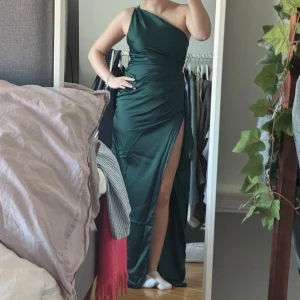 Grön one-shoulder långklänning - Jätte vacker grön långklänning med one-shoulder design och hög slits. Aldrig använd och med prislappen kvar. Skriv för fler bilder❣️❣️