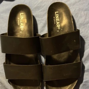 Svarta sandaler från Linear - Snygga svarta sandaler från Linear med breda remmar. Perfekta för en avslappnad stil. Sandalerna har en enkel design och är lätta att matcha med olika outfits.