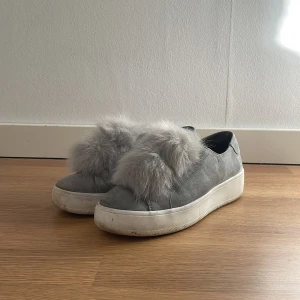 Grå sneakers med fluff från Steve Madden - Snygga grå sneakers från Steve Madden med en unik pälsdetalj på ovansidan. Smutsiga på sulan men går enkelt att tvätta bort.