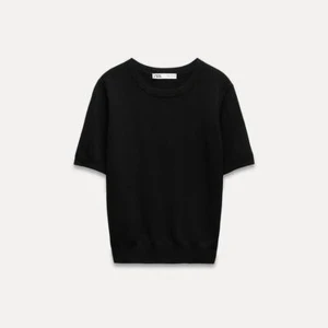 Svart kortärmad tröja från Zara - Säljer en stilren svart kortärmad tröja från Zara. Perfekt för en minimalistisk look. Tröjan har en rund halsringning och är gjord i ett mjukt material som ger en bekväm passform.