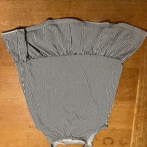 Randig offshoulder topp från H&M - Säljer en söt randig offshoulder topp från H&M i svart och vitt. Toppen är perfekt för varma sommardagar. Den är tillverkad i ett mjukt och bekvämt material.