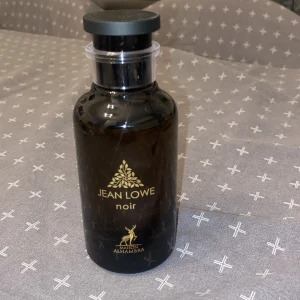 Jean Lowe Noir Parfym - . Jean Lowe Noir från Maison Alhambra har en stilren design med gyllene detaljer. Perfekt för den som söker en sofistikerad doftupplevelse. Luktar som ombre nomad från Louis Vuitton. Endast använd 2 gånger. 