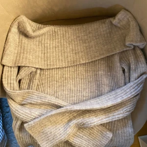 Beige ribbad offshoulder tröja från H&M - Säljer en mysig beige ribbad offshoulder tröja! Perfekt för en trendig look med långa ärmar och en bekväm passform. Passar utmärkt till både jeans och kjol!💗