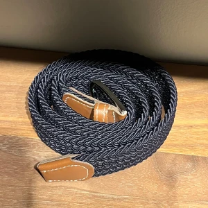 Helt nytt bälte från Onewear - Snyggt flätat bälte i mörkblått med stilrena bruna läderdetaljer. Perfekt för att ge en extra touch till din outfit. Bältet har en flexibel design som gör det enkelt att justera efter behov. Nypris 349kr (inte helt säker) Längd: 105cm