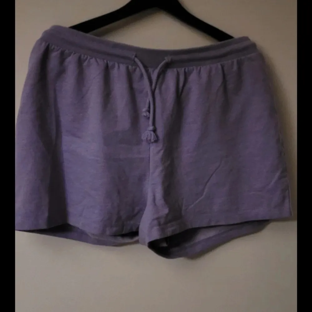 Snygga lila shorts med knytband i midjan. Perfekta för en avslappnad stil. De har en loose passform och är gjorda i ett mjukt material som känns skönt mot huden.. Shortsit.