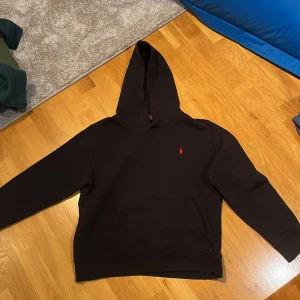 Svart hoodie från Polo Ralph Lauren - Tja, säljer en stilren svart hoodie från Polo Ralph Lauren med det klassiska röda loggan. Säljer då den är för liten sen länge tillbaka. Endast använd 1 eller 2 gånger och är därför i mycket fint skick! Priset kan alltid diskuteras🤝💫