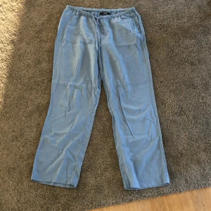 Blå linnebyxor från BikBok - Säljer ett par bekväma blå linnebyxor från BikBok i storlek M. Byxorna har en loose passform med elastisk midja och dragsko för extra komfort. Perfekta för en vår och sommar!😍 Byxorna är som sagt i storlek M och på mig som är M så sitter de ganska tajt medans på en xs-s sitter de lite mer pösigt. Byxorna är även low waist❤️❤️